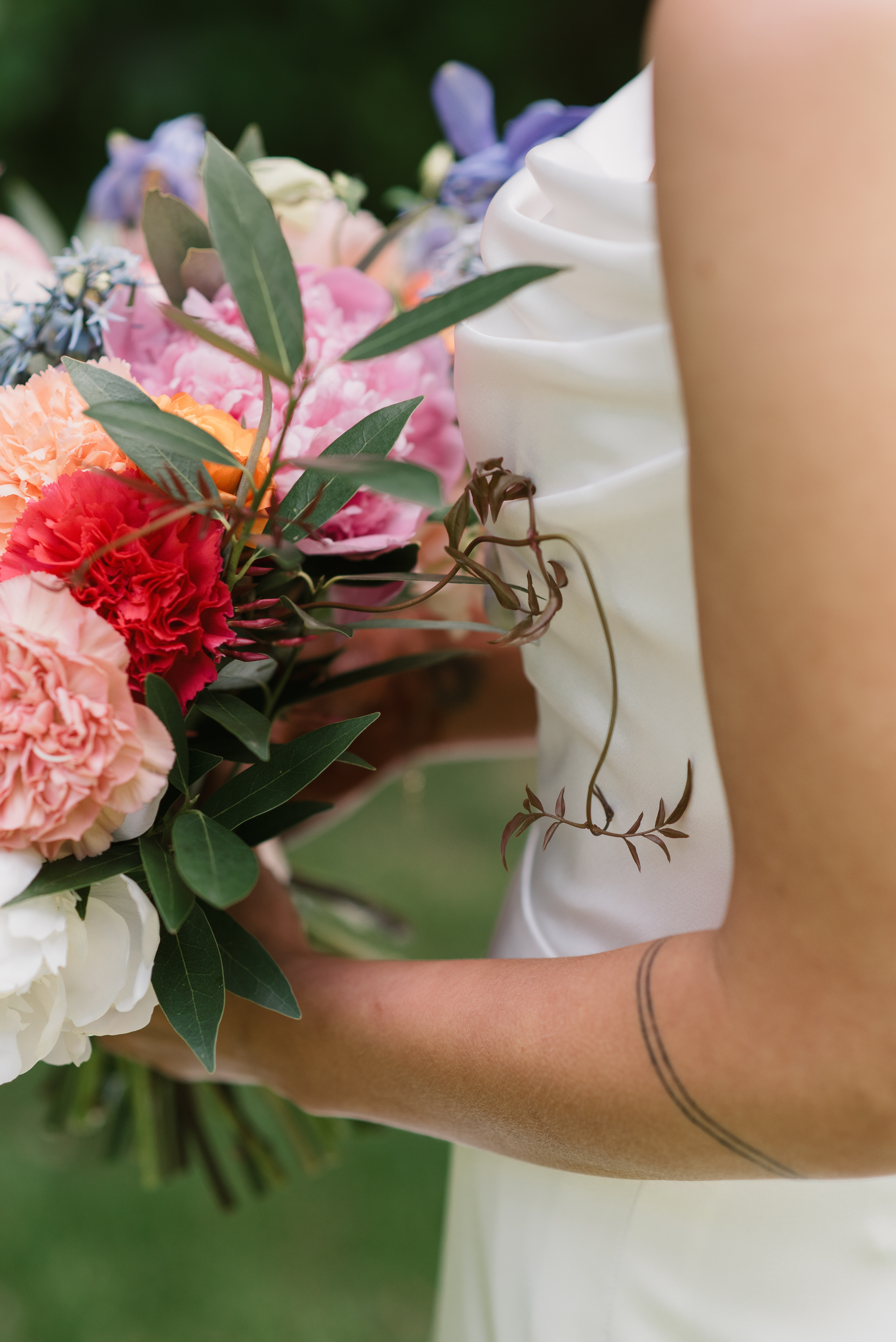 close up of wedding bouquet and bride's arm tattoo