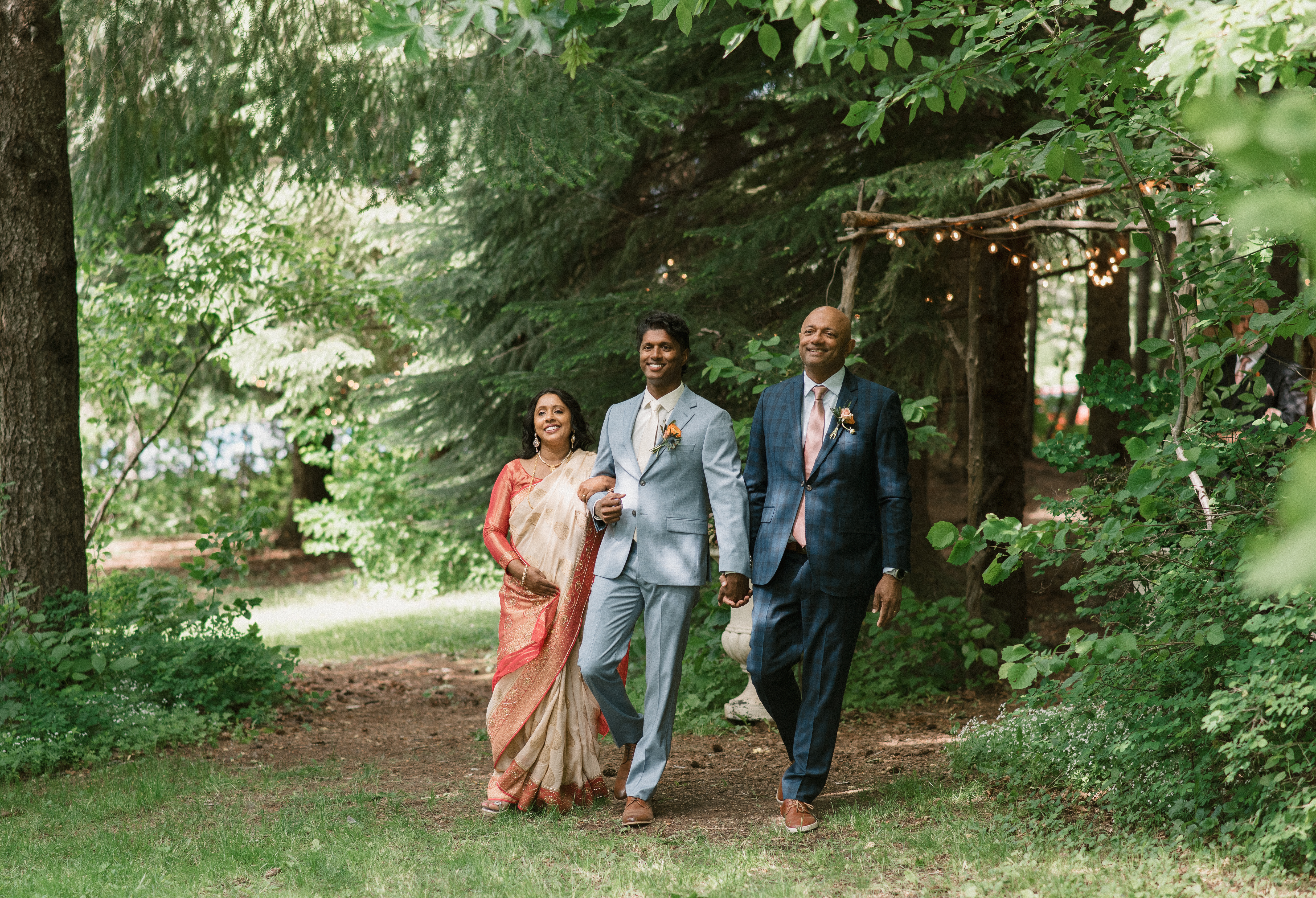 groom walking down the isle with his parents