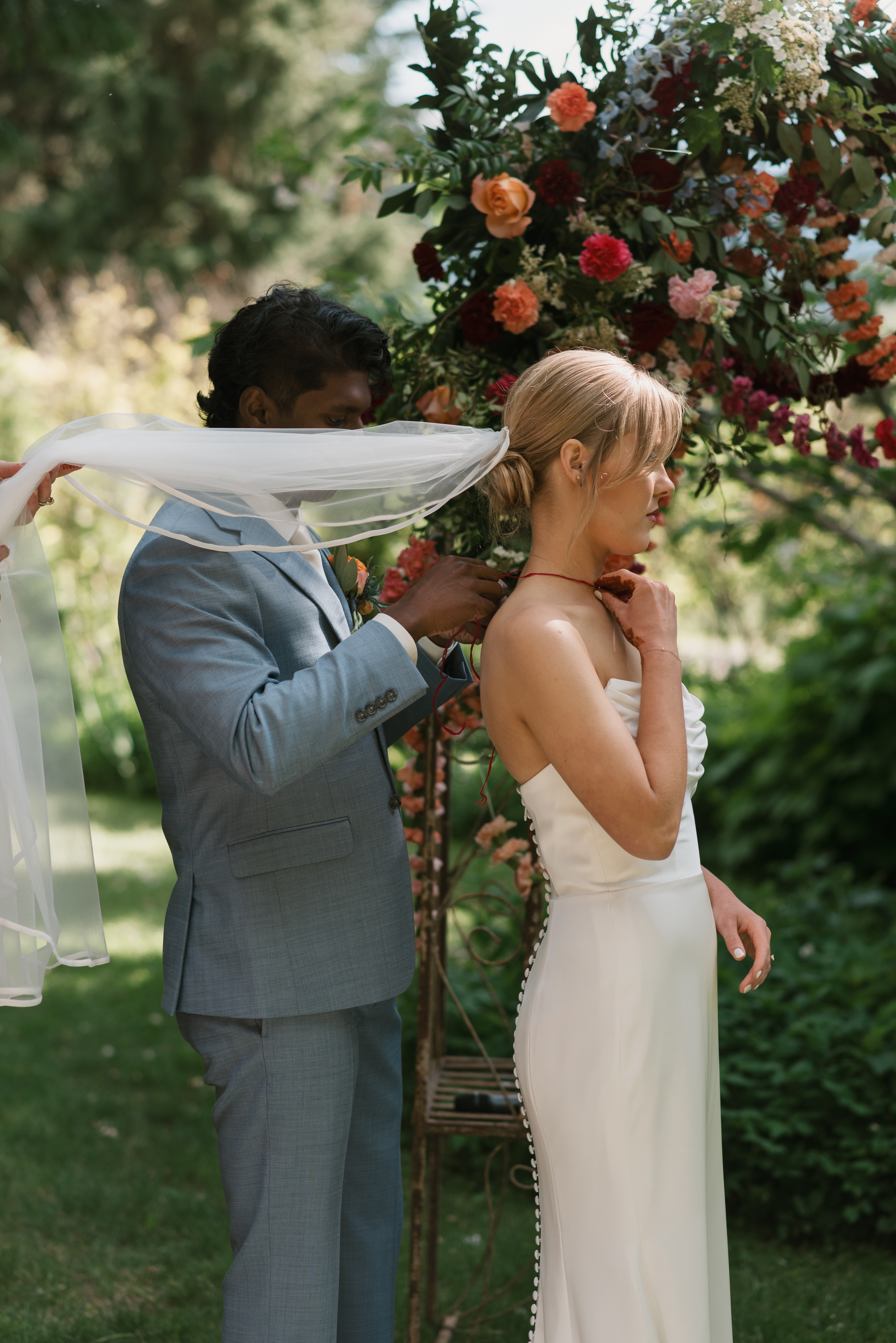 groom tying a traditional indian necklace on the bride during the ceremony at mt hood organic farms wedding