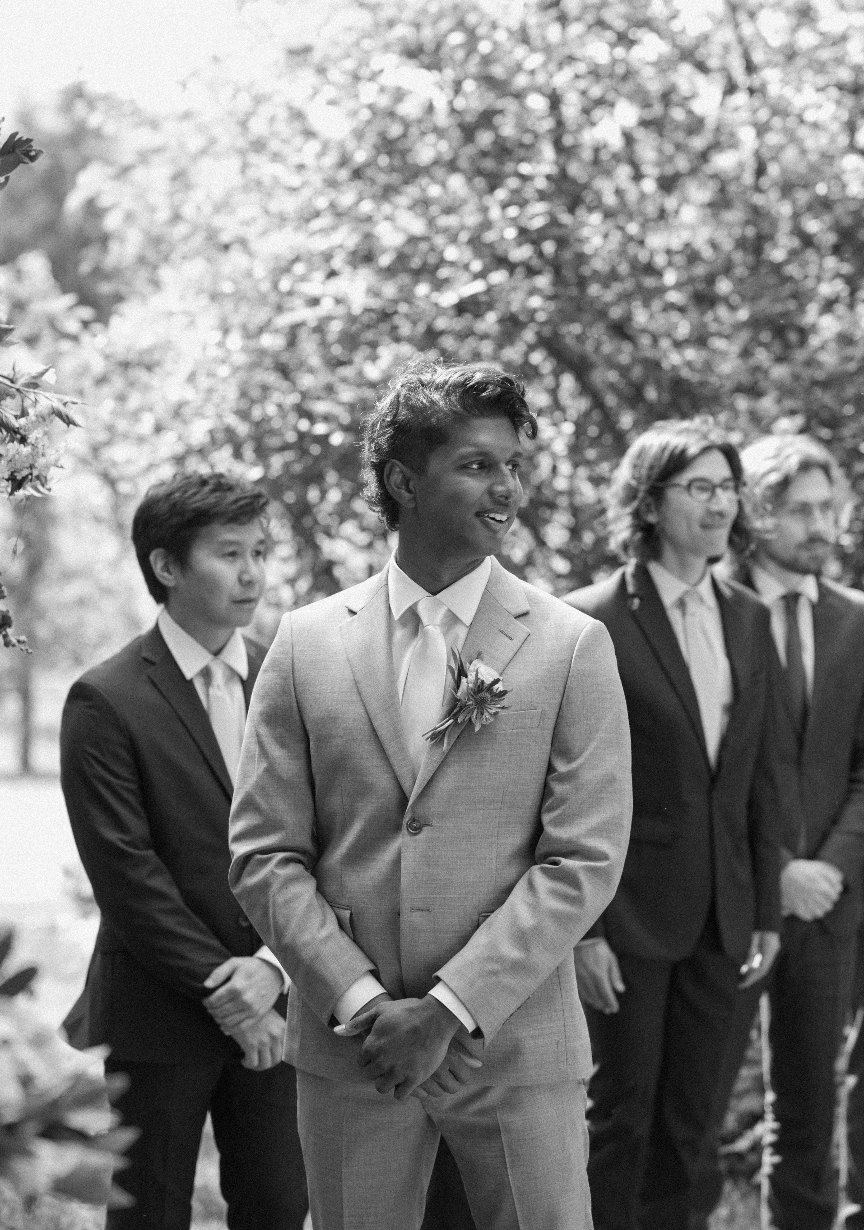 black and white photo of the groom waiting for his bride to walk down the isle