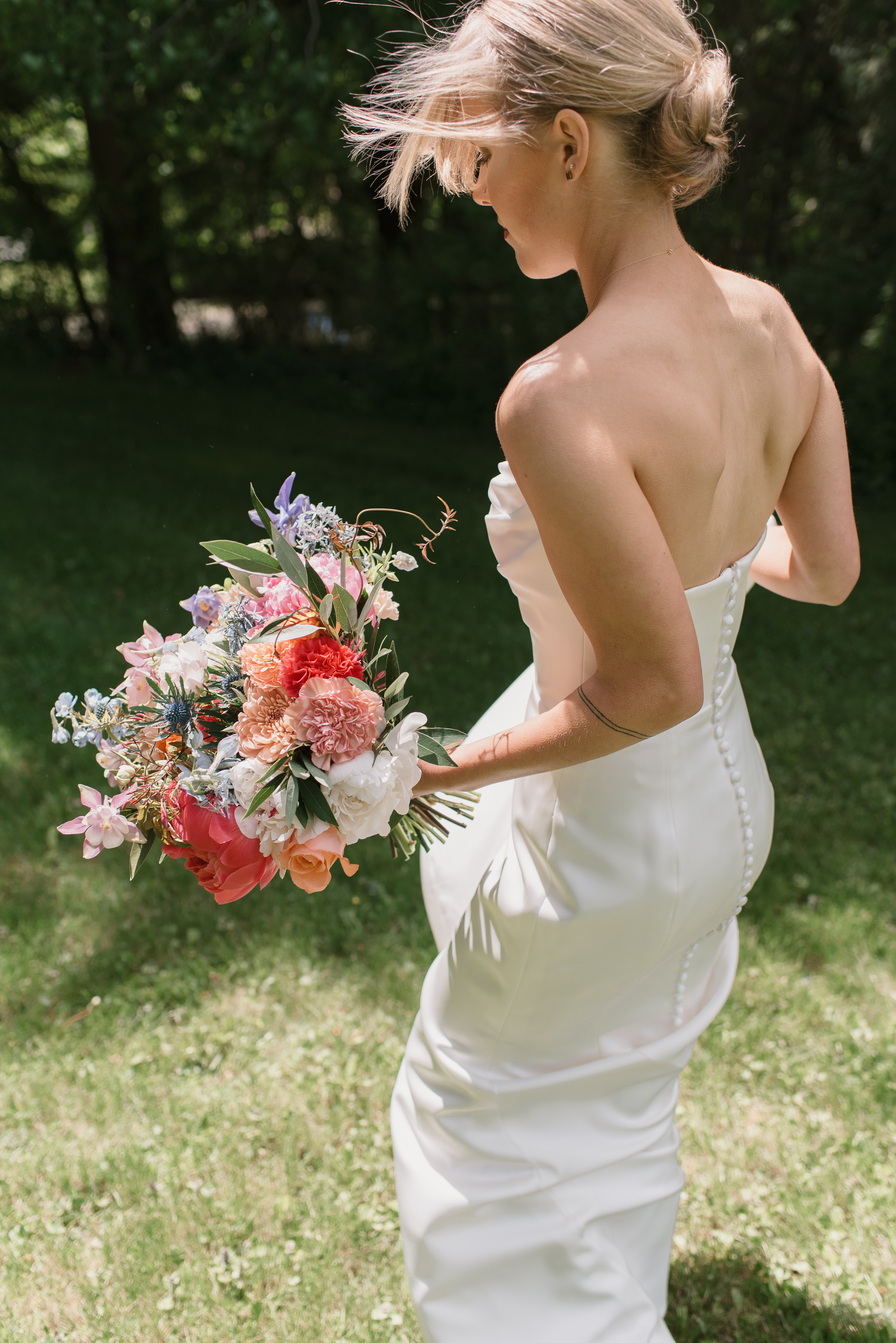 candid photo of bride walking while holding her dress and bouquet