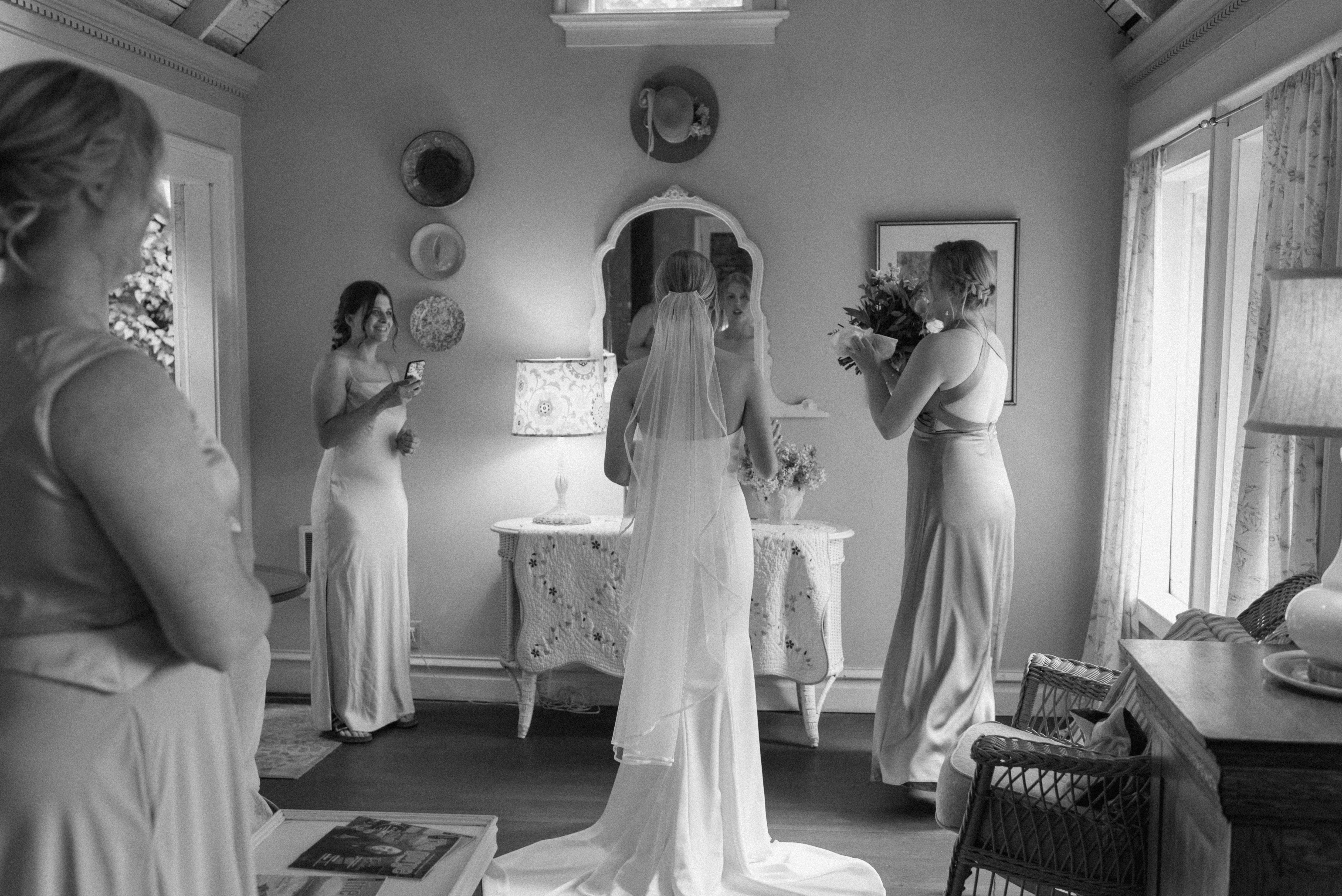 black and white of bride with her closest family helping her do the finishing touches