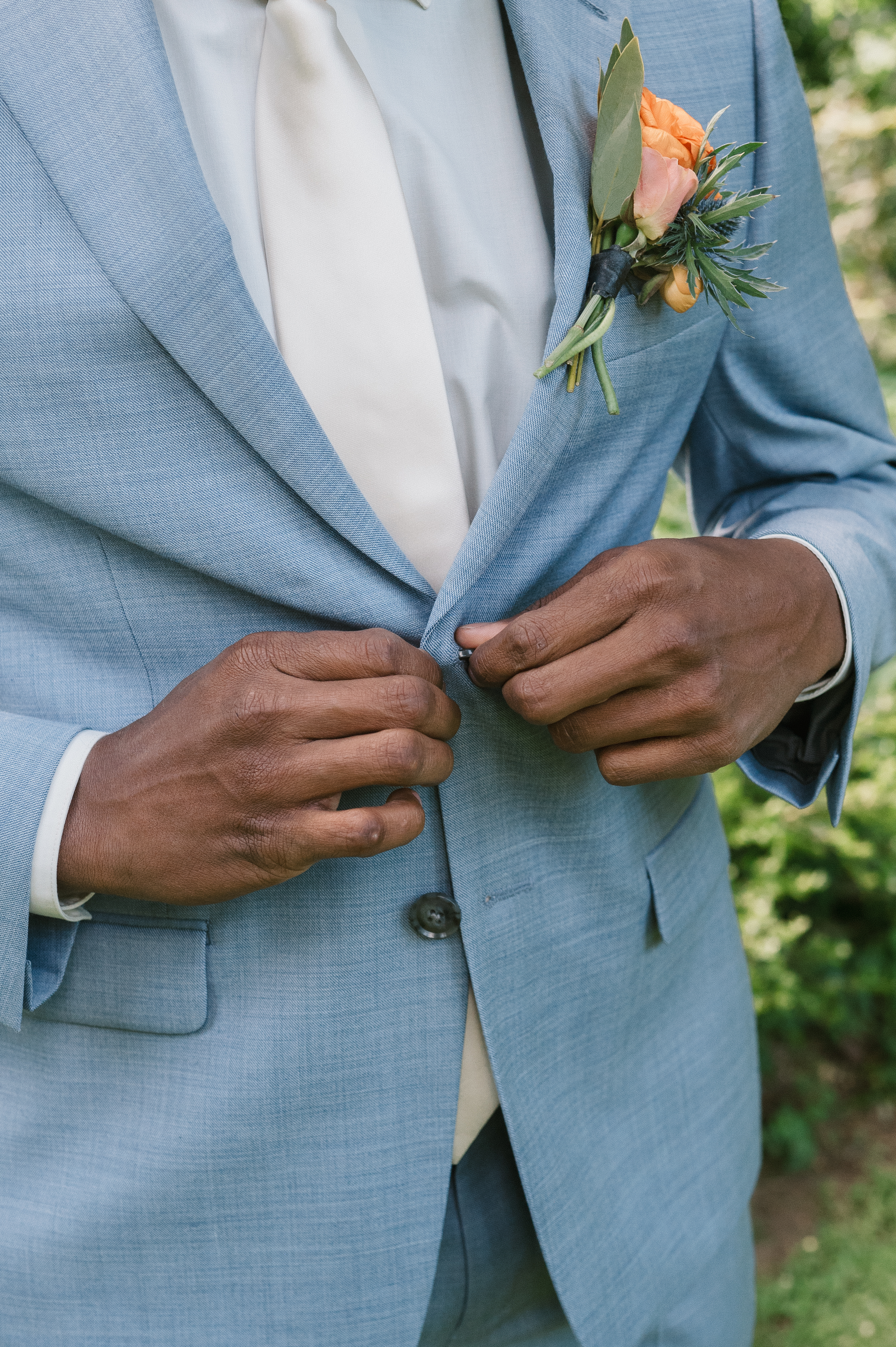 groom buttoning up his suit jacket at mt hood organic farms wedding