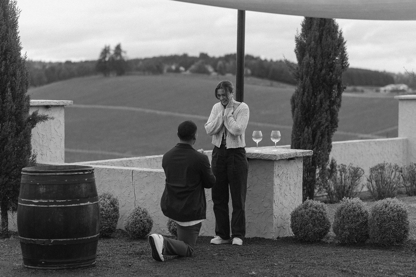 black and white of man proposing at a winery