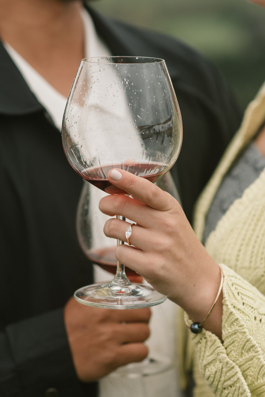 engagement ring shot while holding a wine glass