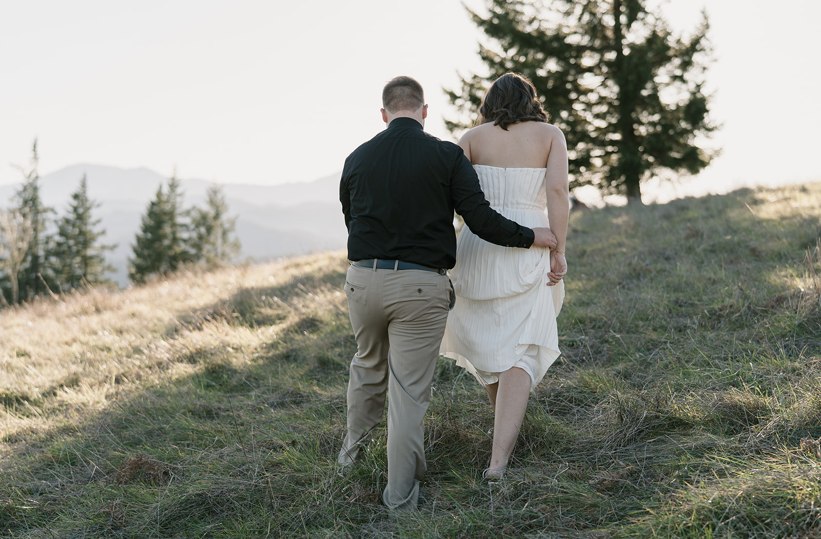 future groom helping hold future brides dress