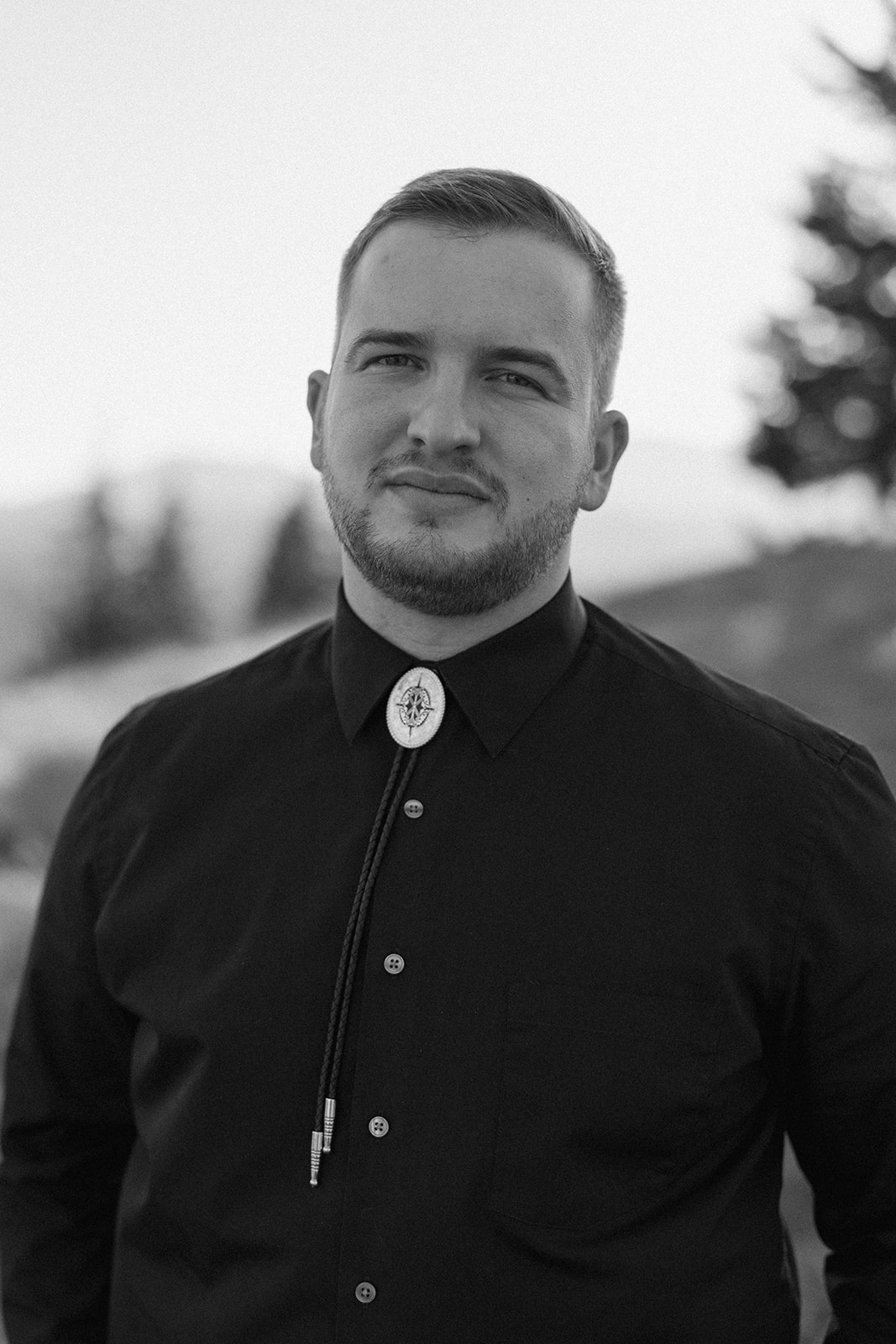 solo black and white portrait of groom with bolo tie