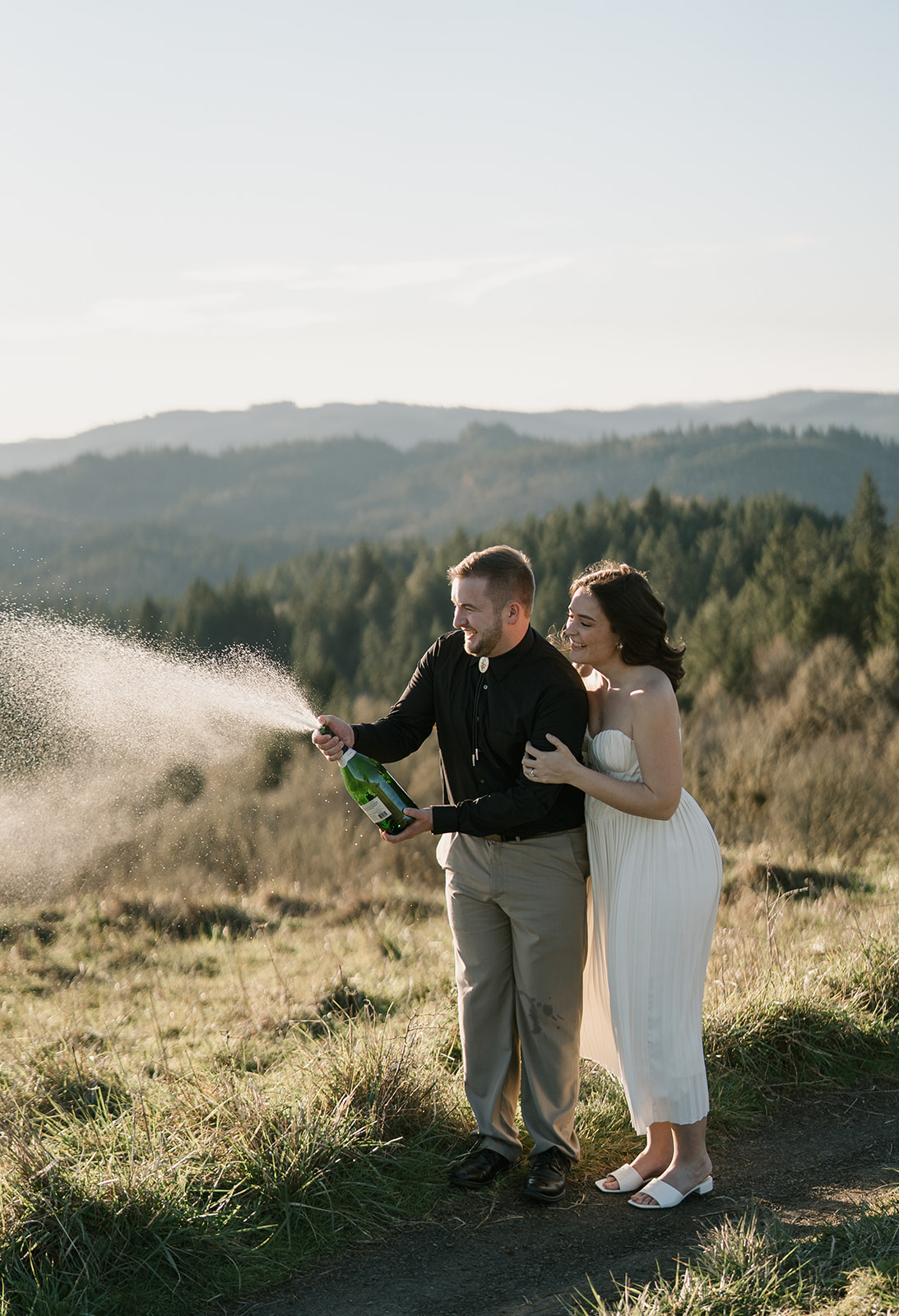 champagne spray for couple at engagement session