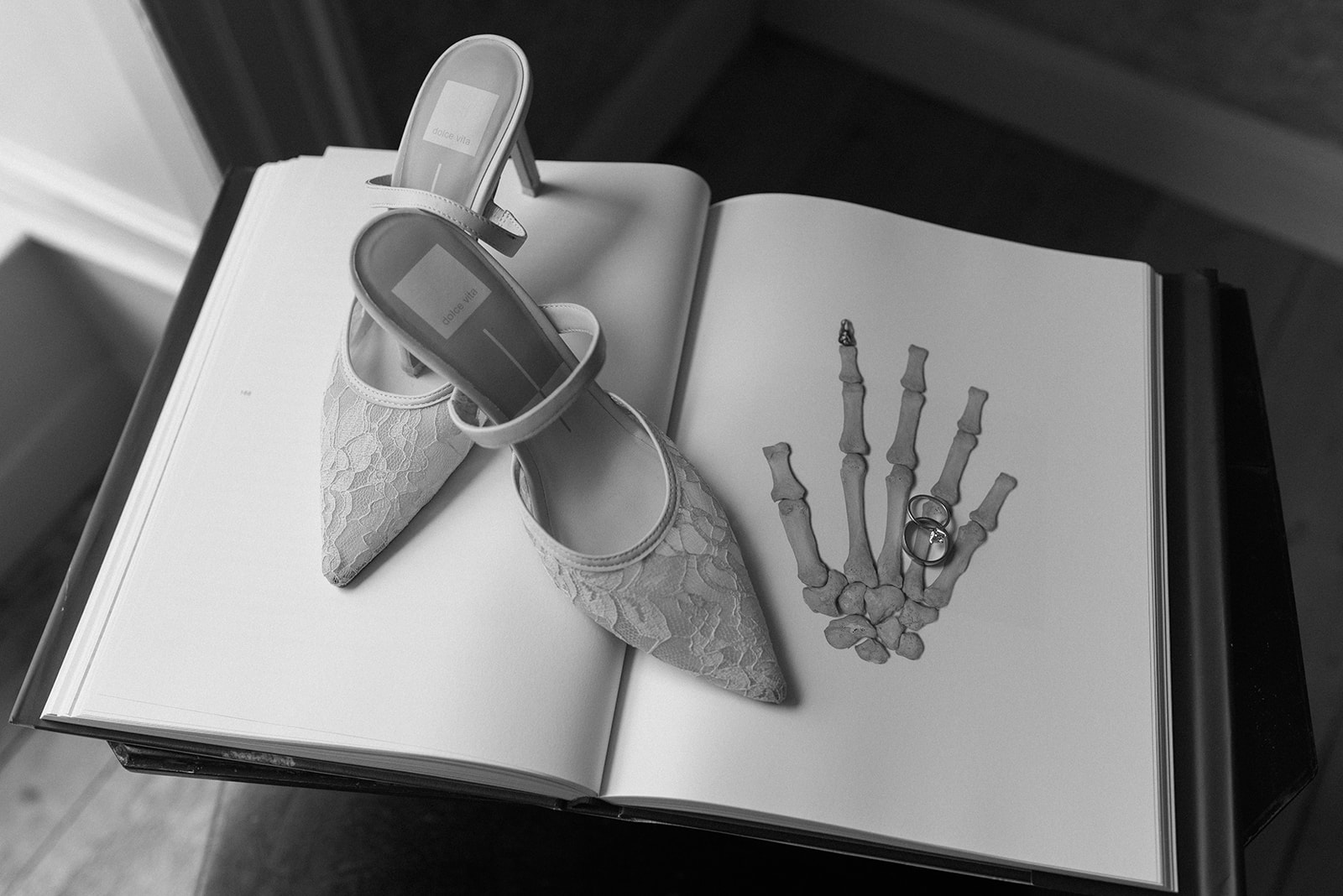 black and white flatlay of wedding shoes and rings