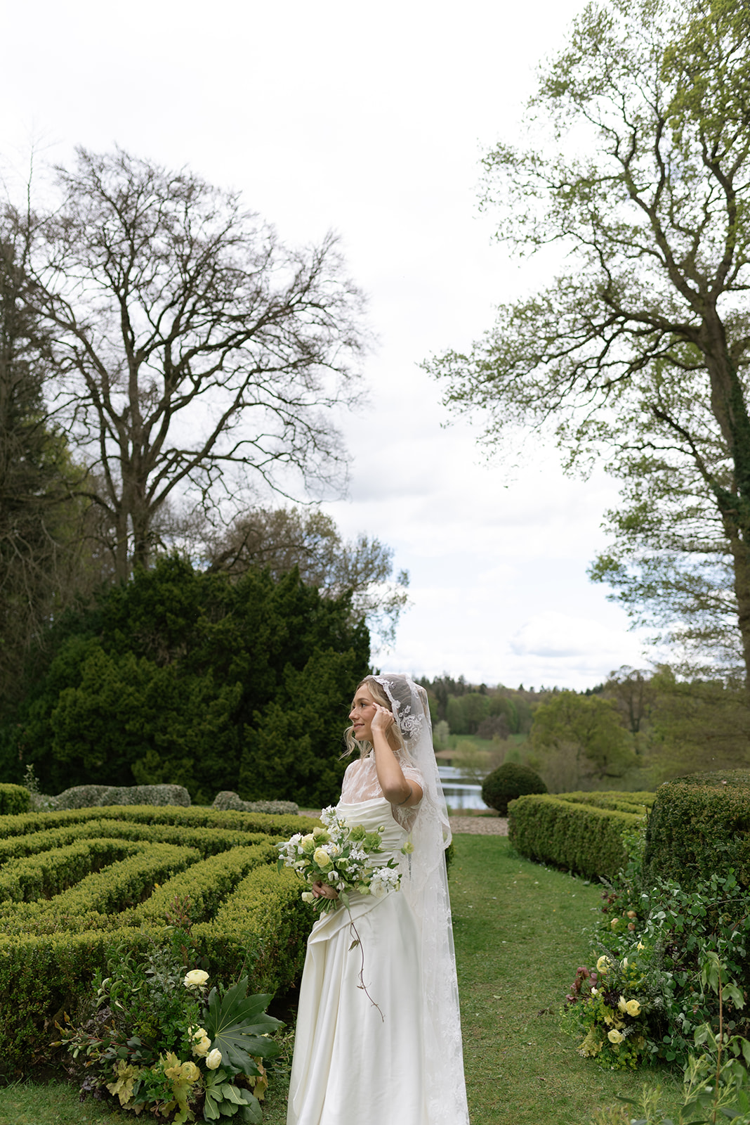 bride standing in a lush garden at Hilton park manor in Ireland