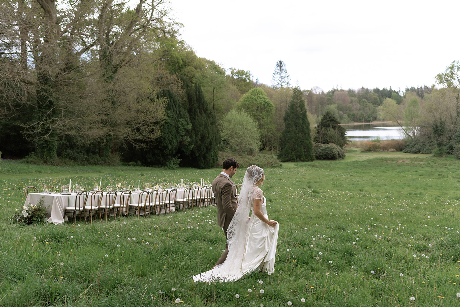 Bride and groom sharing frolicking under warm light in Hilton Park meadow, Ireland intimate wedding reception