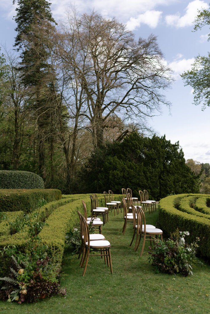 Outdoor ceremony in the gardens of Hilton Park Manor with guests seated amongst hedges, Ireland intimate wedding