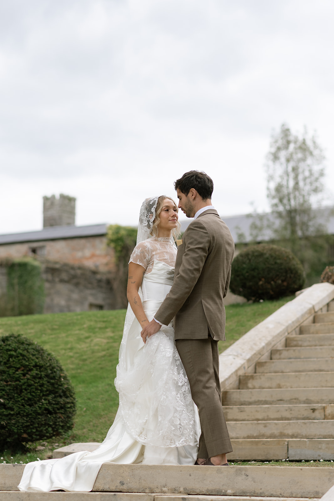 couple looking at each other on the grand steps at hilton park manor in ireland