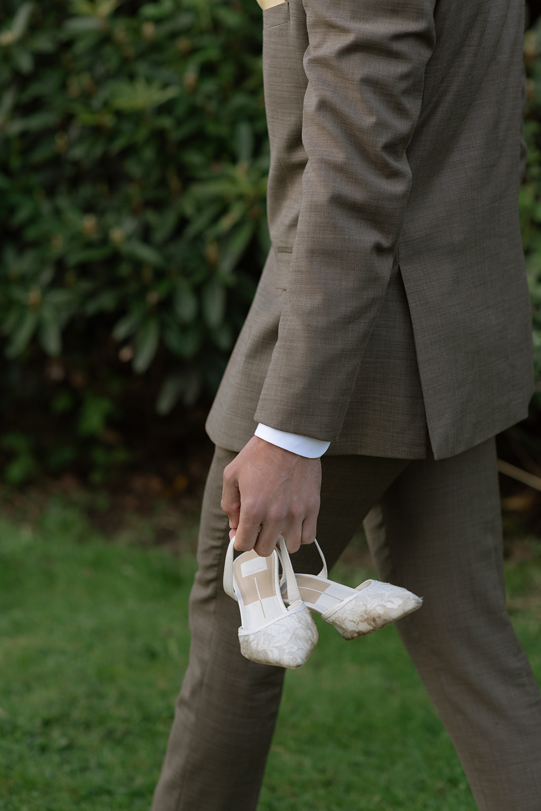 groom carrying bride's shoes after intimate wedding in ireland