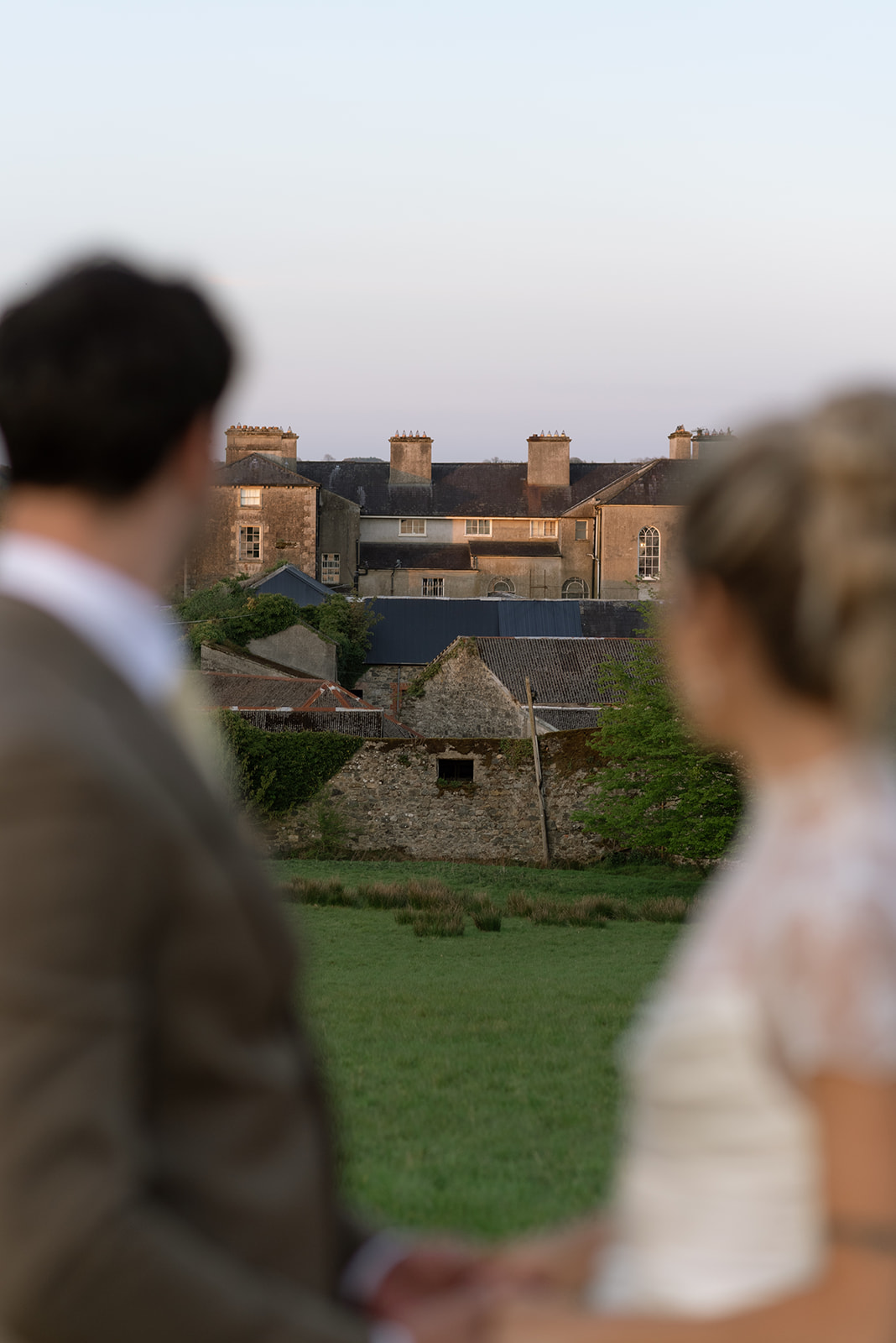 couple looking back at hilton park manor in ireland at sunset